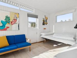 伦德Holiday Home Sylvia - 450m from the sea in Djursland and Mols by Interhome的一间卧室配有一张床和一张蓝色的沙发