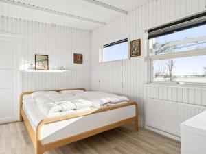 伦德Holiday Home Sylvia - 450m from the sea in Djursland and Mols by Interhome的一间白色卧室,卧室内配有一张床,房间设有窗户