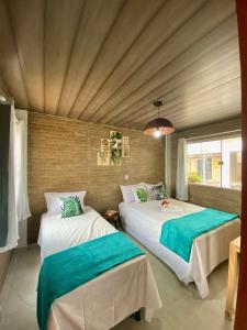 路易斯科雷亚Luar do Maramar Chalés的一间卧室设有两张床和窗户。