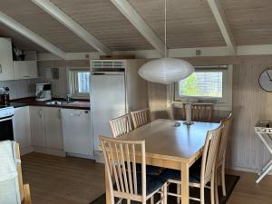斯特兰比Holiday Home Santeri - 180m from the sea in NE Jutland by Interhome的厨房配有桌椅和灯具