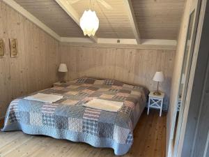斯特兰比Holiday Home Santeri - 180m from the sea in NE Jutland by Interhome的卧室配有一张床铺,位于带木墙的房间内
