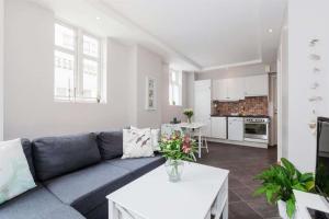 卑尔根佩佩斯公寓的一间带蓝色沙发的客厅和一间厨房