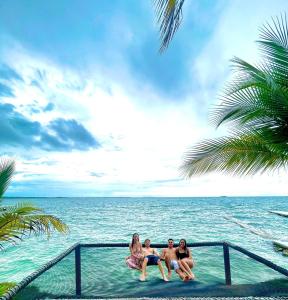 格兰德岛Hotel Cocoliso Island Resort的三个妇女坐在海洋附近的水里