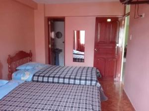 瓦拉斯Villa hospedaje的一间卧室设有一张床和一扇红色的门