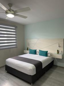 瓜达拉哈拉Constanza Lofts Executives en Zapopan Jalisco的一间卧室配有一张带蓝色枕头的大床