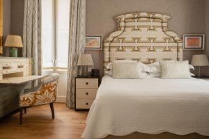 米兰Vmaison Brera Milano的一间卧室配有一张大床、一张桌子和一把椅子