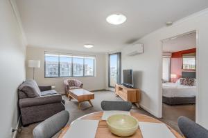 堪培拉CityStyle Apartments的客厅配有沙发和1张床