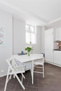 卑尔根佩佩斯公寓的白色的厨房配有白色的桌子和椅子