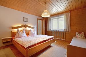 布里克森谷地霍普夫加尔滕谷格霍夫公寓的木制客房内的一间卧室,配有一张床