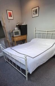 HillsboroughSerene Homes Sheffield, Private Ensuite Velux Room的一张位于带微波炉的房间的床
