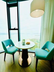 下龙湾Panoramic sea homestay的窗户间里的一张桌子和两把椅子