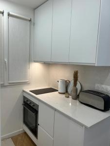 巴黎Cocooning & Cosy Apartment in Center Paris 17的厨房配有白色橱柜和台面
