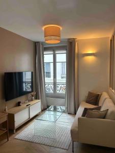 巴黎Cocooning & Cosy Apartment in Center Paris 17的带沙发和电视的客厅