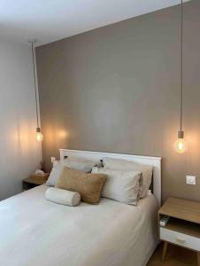 巴黎Cocooning & Cosy Apartment in Center Paris 17的卧室配有带两盏灯的白色床