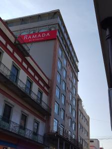 坦皮科Ramada by Wyndham Tampico Centro的建筑的侧面有标志