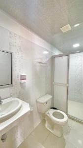 CurumaníHotel BJ Curumani的白色的浴室设有卫生间和水槽。
