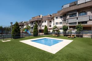 马拉加Ven descansa y conoce Málaga的一座大型公寓楼,在庭院里设有游泳池