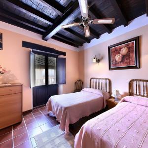 Villar de Plasencia卡萨蒂亚艾米利亚酒店的一间卧室配有两张床和吊扇