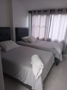 卡利San Joaquín B&B的卧室内的两张床,配有白色床单