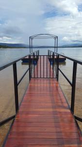圣若昂-达巴拉Casa de temporada no Lago de Furnas-acesso a represa的水面上一个带两把椅子的码头