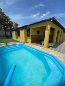 考卡亚Casa Beira Mar - Praia Icaraí - CE的一座大蓝色游泳池,位于房子前