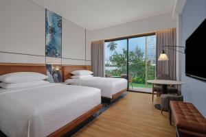 拉古洼Four Points by Sheraton Bintan, Lagoi Bay的酒店客房设有两张床和大窗户。