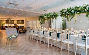 托基Hampton By Hilton Torquay的一间设有一排桌椅的鲜花客房