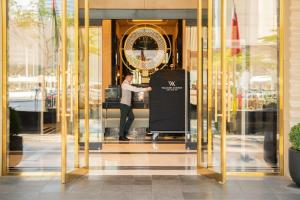 多哈Waldorf Astoria Doha West Bay的站在玻璃门内的人