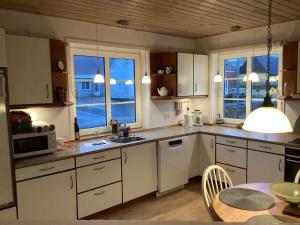 北内伯尔Holiday home Nørre Nebel III的厨房配有白色橱柜、餐桌和用餐室
