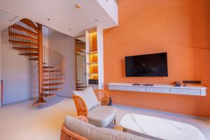 奥南海滩Hotel Adam Krabi的客厅设有带平面电视的橙色墙壁。