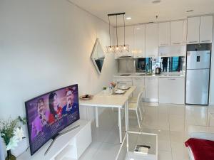 吉隆坡Summer suites klcc by Peaceful Nest的白色的厨房配有餐桌和电视。