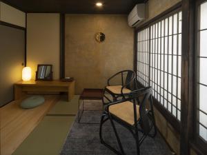 大洲NIPPONIA HOTEL Ozu Castle Town的一间带椅子和桌子的房间以及窗户