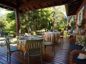 布希奥斯Hotel Liberdade Búzios的木甲板上设有桌椅的餐厅