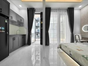 胡志明市Newhome luxury apartment的一间卧室配有一张床、一间厨房和一张桌子