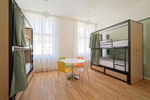 布拉格Luma Terra Prague Hostel的客房设有两张双层床和一张桌子及椅子。