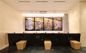 泉佐野Odysis Suites Osaka Airport Hotel的墙上有四幅画作的房间