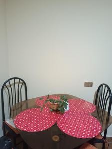 波托西Apartamento cómodo的一张餐桌,配有两张红色的波尔卡圆桌