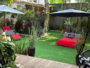 弗洛里亚诺波利斯UFSC Guest House的花园设有红色的床和遮阳伞
