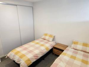 墨尔本Modern Apartment Airport Area的一间卧室设有两张单人床,彼此相邻。