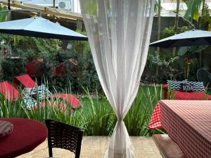 弗洛里亚诺波利斯UFSC Guest House的一个带桌子和遮阳伞及桌椅的庭院