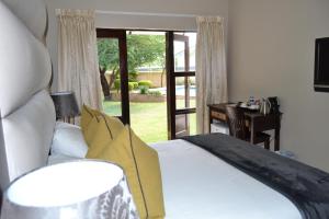 哈博罗内卡皮塔尔旅馆的一间卧室设有一张床和一个滑动玻璃门