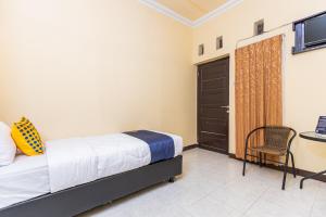 马卡萨SPOT ON 1990 Pondok Ripuji的卧室配有床、椅子和门
