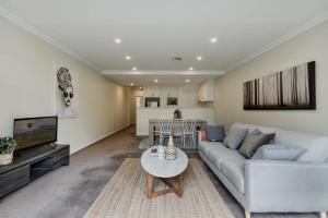 金斯顿Modern apartment in the heart of Canberra的客厅配有沙发和桌子