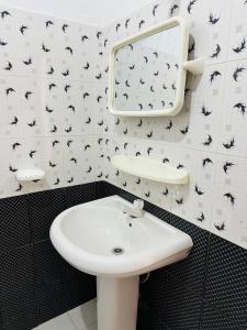 科伦坡Blue Lotus Garden Hotel piliyandala的浴室设有白色水槽和黑白瓷砖。