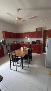 马斯喀特Basil Hostel的厨房配有木桌、椅子和冰箱