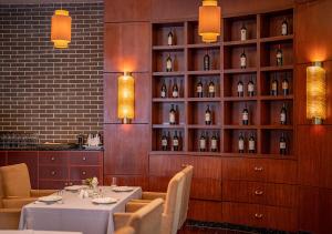 义乌贝斯特韦斯特（精品）海洋酒店的用餐室配有桌子和瓶装葡萄酒