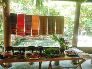 Hương Bá ThướcHợi liên homestay的一张桌子,上面有食物和椅子,在游泳池前