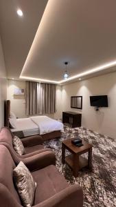 Al ḨawīyahRadiha Hotel Suites的带沙发和床的大型客厅