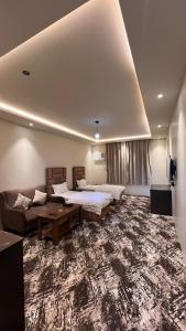 Al ḨawīyahRadiha Hotel Suites的大房间设有两张床和一张沙发