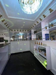 拉各斯Ikorodu Guest House的一间大型白色客房,配有吊灯和酒吧